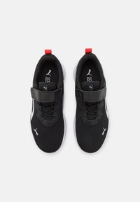 Scarpe sportive nere con tomaia in rete, dettagli bianchi e una chiusura in Velcro. Include un pull-tab rosso per facilitare l'indossamento.