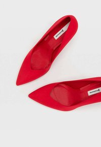 Rode pointed-toe hoge hakken van zacht suède-achtig materiaal, met een gladde textuur en een slank ontwerp. Comfortabele binnenvoering.