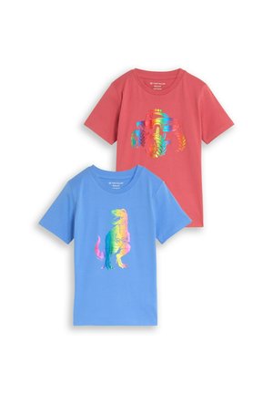 Deux t-shirts enfants à manches courtes avec un dinosaure aux couleurs de l’arc-en-ciel sur un t-shirt bleu et un monster truck aux couleurs de l’arc-en-ciel sur un t-shirt rouge.
