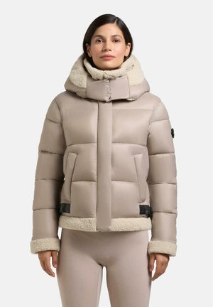 Puffjakke i lys beige med høj krave og pelsfor. Har kviltet design, kontrasterende beige pelsmanchetter og nederste kant samt sidelommer.