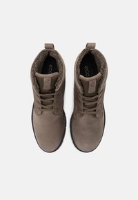 Botas de ante marrón con cordones, cuellos acolchados, forro interior texturizado y suelas de goma; diseño minimalista con una etiqueta de logo en la lengüeta.