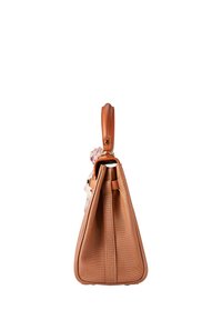 Sac à main texturé beige avec une poignée en cuir et un accessoire en forme de fleur en tissu rose, présenté de côté sur un fond blanc.