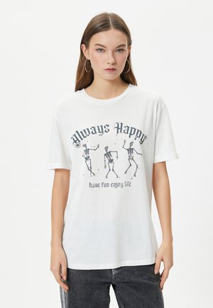 Hvid bomulds T-shirt med grafisk tryk af dansende skeletter og teksten "Always Happy" i sort, rund hals, korte ærmer.