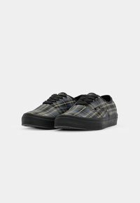 Black and yellow plaid canvas sneakers with a low profile, black rubber sole, and black laces, featuring a smooth texture and round toe.