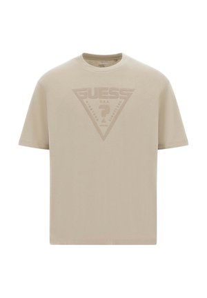T-shirt beige a maniche corte con logo Guess a triangolo in rilievo e punto interrogativo al centro del petto, collo rotondo.