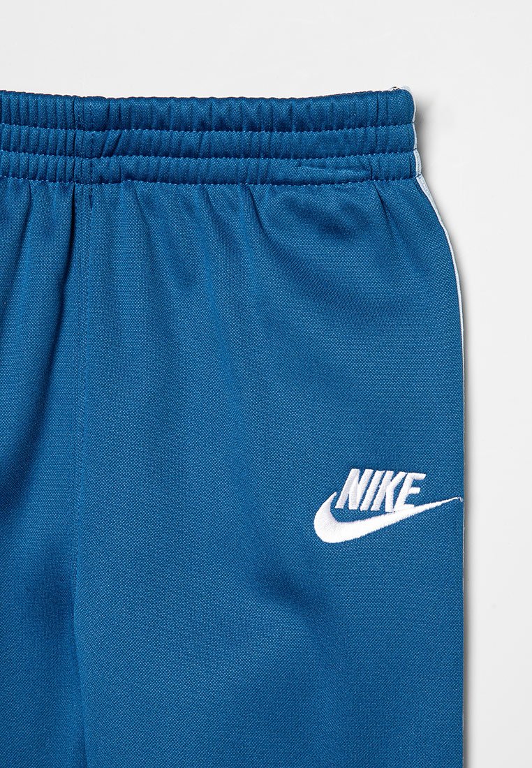 Pantalones cortos deportivos azules con una tela texturizada, cinturilla elástica y logo blanco de Nike en el lado izquierdo. Presenta franjas laterales blancas.