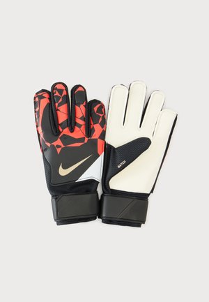 Para rękawic bramkarskich Nike, jedna strona wewnętrzna biała, a druga zewnętrzna czarna z czerwonym geometrycznym wzorem i logo marki.