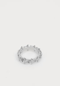 Sudraba metāla gredzens ar izvirzītiem zvaigžņu formas iegremdējumiem, kas vienmērīgi izvietoti ap joslu, uz balta fona.