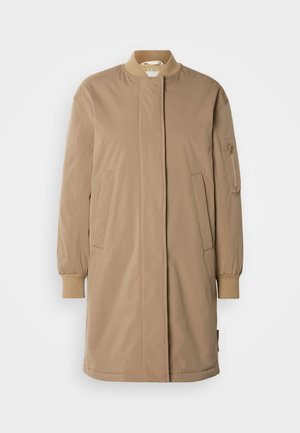 Cappotto lungo color cannella con collo alto, chiusura frontale con zip e polsini elasticizzati. Presenta due tasche laterali e una tasca con zip sul braccio sinistro.