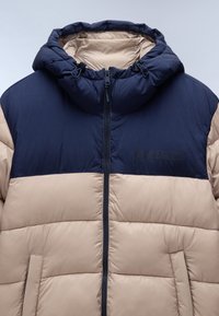 Giacca imbottita con cappuccio blu navy e parte superiore blu, parte inferiore beige, chiusura frontale con zip e tasche laterali, caratterizzata da un tessuto testurizzato.