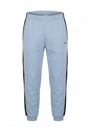 Pantalones deportivos azul claro con rayas negras en los laterales, cintura elástica, puños en los tobillos y un pequeño logotipo de cocodrilo en el muslo izquierdo.