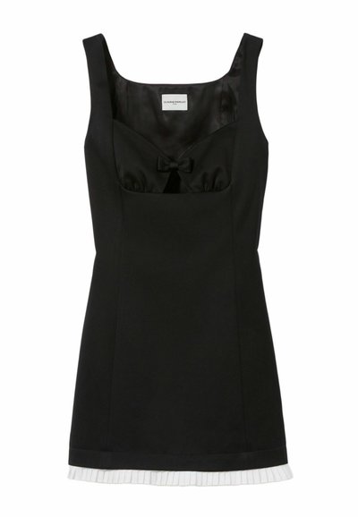 Vestido negro sin mangas con un corpiño ajustado, detalle de lazo en el escote y un dobladillo blanco plisado, hecho de una tela suave.