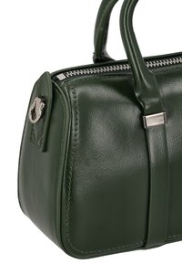 Groene leren handtas met een afgeronde vorm, gedetailleerd stiksel en zilverkleurige hardware accenten, voorzien van korte handvatten en een bovenste rits.