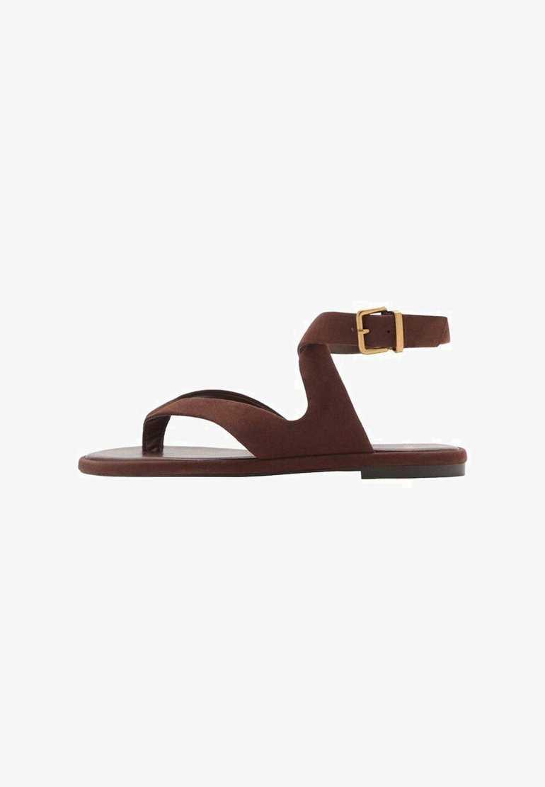 Sandal in suede marrone con design slip-on, cinturino alla caviglia con fibbia e suola piatta. Punta aperta con una texture liscia.