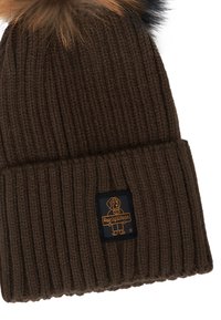 Cappello in maglia a coste marrone per l'inverno con orlo piegato, decorato da un pompon in pelliccia sintetica marrone e nera, e una piccola patch con logo di un cane sul polsino.