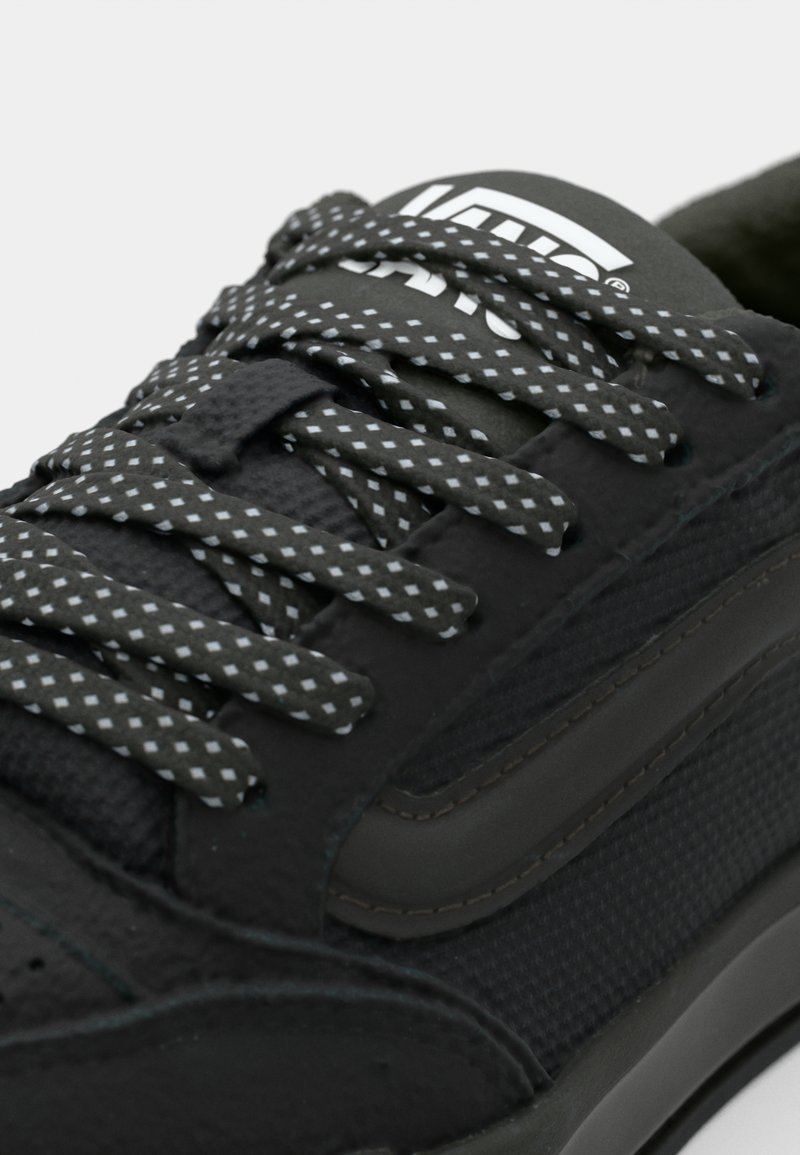Czarny sneaker z teksturowanej syntetycznej cholewki, ciemnoszarym gumowym podbiciem, wzorzystymi sznurowadłami z białymi akcentami i logo na języku.