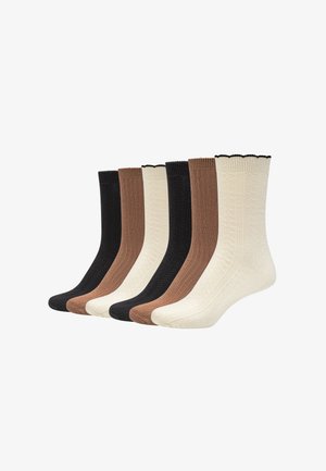 Zes paar geribbelde gebreide crew sokken in zwart, bruin en crèmekleuren, naast elkaar gelegd op een witte achtergrond.