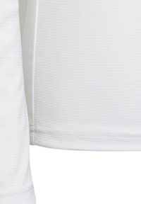 Camisa blanca texturizada con patrón de ribete horizontal, mangas cortas y dobladillo recto. Tejido suave con un ligero brillo.