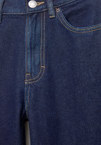Jeans in denim blu scuro con una texture liscia, dotati di cuciture dorate, una chiusura con bottone argentato e tasche frontali.