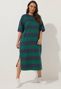 Raitatakki maksimekko tummanvihreänä ja laivastonsinisenä. Lyhyet hihat, pyöreä kaula-aukko, sivuaukot liikkumisen helpottamiseksi. Yhdistetty valkoisiin lenkkareihin. Puuvillamateriaali.