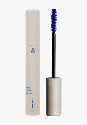 Tube de mascara beige fermé à côté d'un tube ouvert avec une brosse noire et des poils bleu vif.