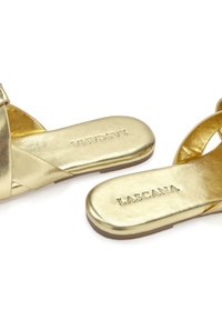 Gold metallic slide sandals with a smooth finish, featuring crisscross straps and embossed "LASCANA" logo on the footbed. Flat soles.