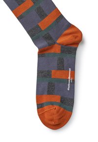 Bunt gemusterte Socke mit einem geometrischen Muster aus Orange, Grün, Grau und Blau auf einem lila Grund; enthält eine texturierte, orange Ferse.