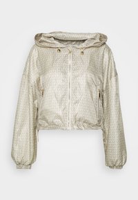Giacca a zip corta beige con cappuccio, caratterizzata da un motivo di testo su tutta la superficie, polsini elasticizzati e due tasche laterali con zip in metallo dorato.