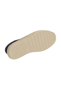 Sål av skor med en beige gummibass och ett strukturerat greppmönster, omgiven av ett svart tygöverkropp med en tjock, vävd kant.