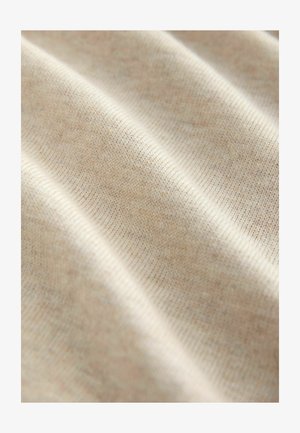 Svijetlo bež tkanina s finom pletenom teksturom, koja prikazuje suptilne varijacije u boji i uske šavove, stvarajući lagane valove i nabore.