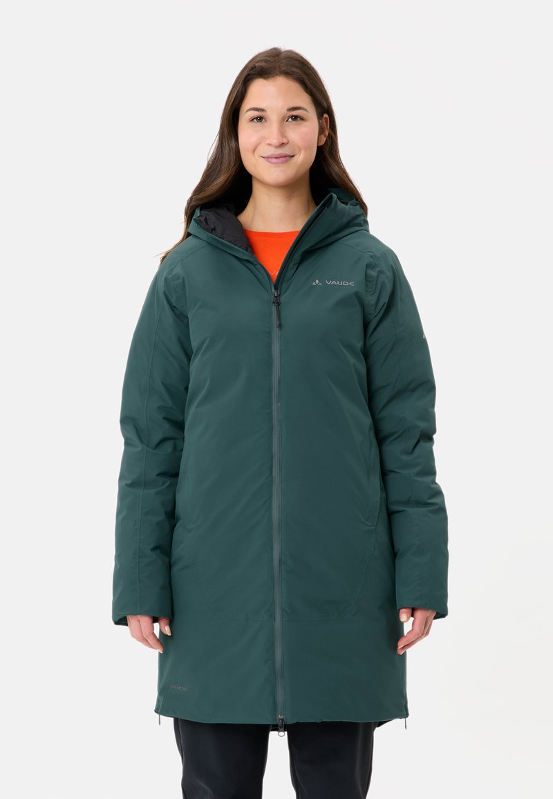 Groene geïsoleerde jas met rits aan de voorkant, capuchon en zwarte accenten. Het ontwerp is gestroomlijnd met een zachte textuur en minimale branding.