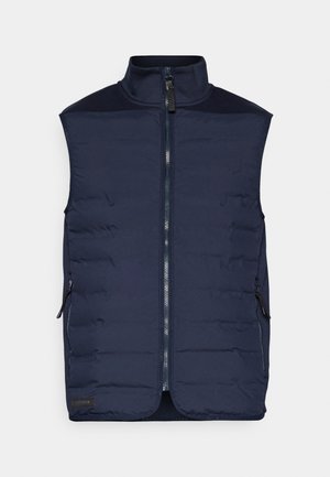 Gilet isolante blu navy con alto colletto, chiusura frontale con zip e due tasche laterali. Presenta una texture trapuntata e pannelli a contrasto sulle spalle.