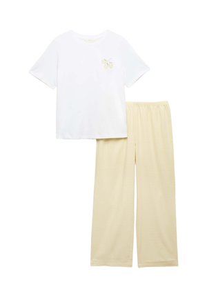 Camiseta blanca de manga corta con gráfico de limón en el pecho combinada con pantalones sueltos beige claro con cinturilla elástica.