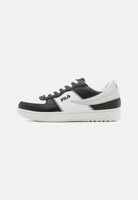 Black and white leather sneakers with perforated toe, contrasting textures, and Fila branding. Features flat laces and a rubber sole.