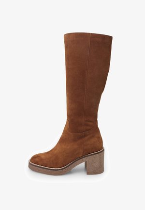 Botte en daim marron jusqu'au genou avec un bloc talon, bout rond et coutures décoratives le long de la semelle. Texture lisse avec des accents minimaux.