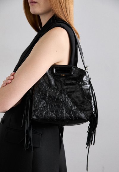 Borsa nera in pelle con una trama stropicciata, manico superiore e dettagli con frange. Presenta un'apertura quadrata e una tracolla in tonalità argento.