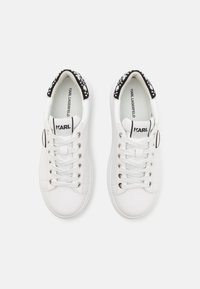 Hvide lædersneakers med en sort mønstret detalje på hælen, rund tå og snørebåndsfront med sølvøjer.