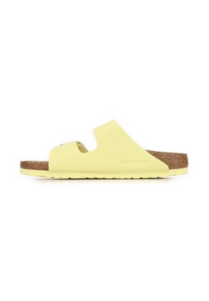 Sandalo giallo modello slide con due cinturini traforati, soletta in sughero e suola in gomma, visto di lato su sfondo bianco.