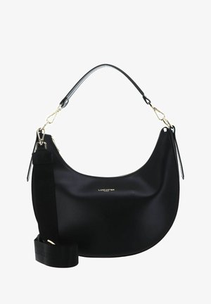 Sac à main noir en matériau lisse avec une forme incurvée. Doté de quincaillerie dorée, d'une bandoulière ronde et d'une sangle épaisse complémentaire.