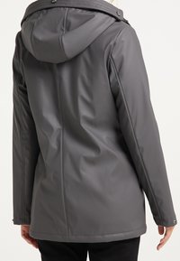 Gray waterproof jacket with a hood, smooth texture, button details at the collar, and seams running down the back for a fitted silhouette.