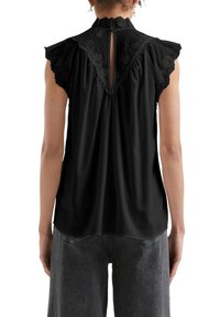 Blusa senza maniche nera con scollatura arricciata, dettagli in pizzo floreale sulle spalle e apertura a goccia sul retro. Tessuto liscio.