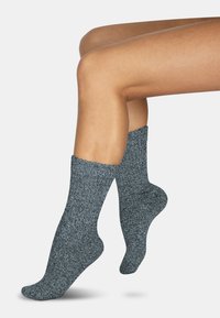 Graue strukturierte Socken mit dickem, weichem Strickdesign, ausgestattet mit einer gerippten Manschette und einer engen Passform rund um Knöchel und Fuß.