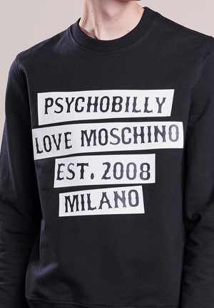 Schwarzer Pullover mit weißem Blocktext auf der Vorderseite: "PSYCHOBILLY LOVE MOSCHINO EST. 2008 MILANO".