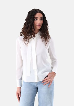 White long-sleeve blouse with a collar, featuring a front tie detail. Made of smooth fabric, with button closure and a relaxed fit.