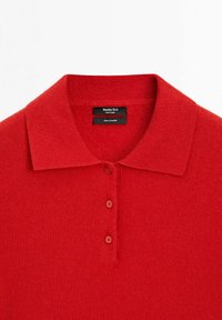 Červený kašmírový polo triko s plochým límcem, třemi knoflíky a texturovanou tkaninou. Štítek uvádí "100% kašmír, Massimo Dutti, Vyrobeno v Číně."
