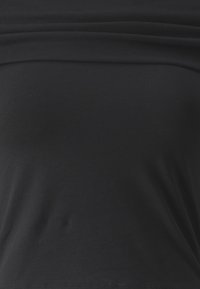 Čierny priliehavý top bez ramienok z hladkej, pružnej látky s preloženým lemom na hornej hrane.