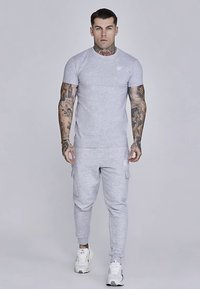 Light gray short-sleeve t-shirt and matching tapered sweatpants, featuring a small logo on the chest and side cargo pockets.