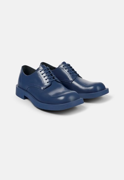 Navyblauwe leren Oxford schoenen met een gladde afwerking, ronde neus en platte rubberen zool. Voorzien van zes oogjes voor de veters en gestikte details.