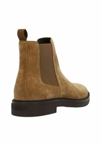 Suede bruine Chelsea-boot met elastische zijpanelen, ronde neus en een stevige donkere zool. Voorzien van een hanguittrek aan de achterkant.