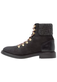 Schwarze Leder-Stiefelette mit einem grauen Stoffkragen, goldenen Ösen und rosa-weißen Schnürsenkeln, ausgestattet mit einer flachen Sohle und einem runden Zehenbereich.